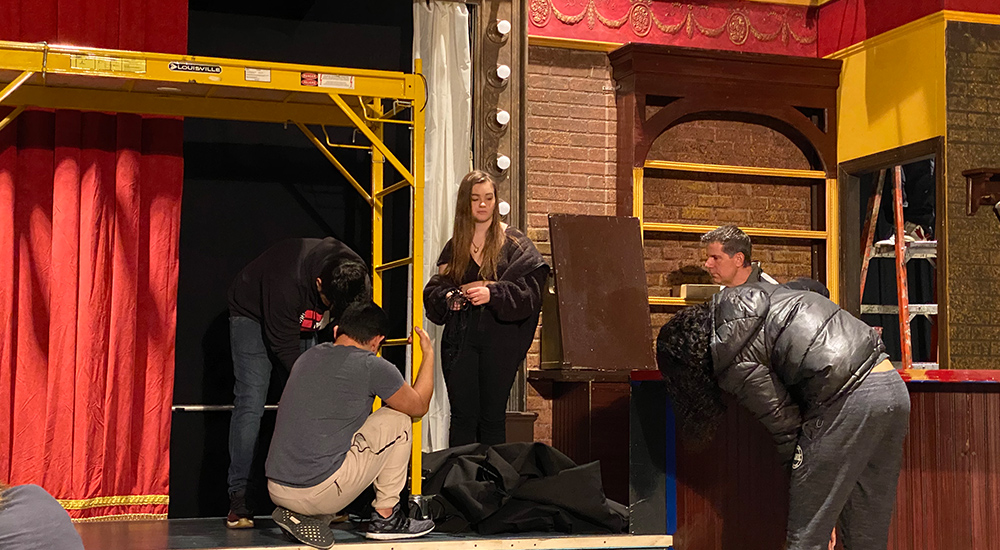 Students on stage creating the sets 